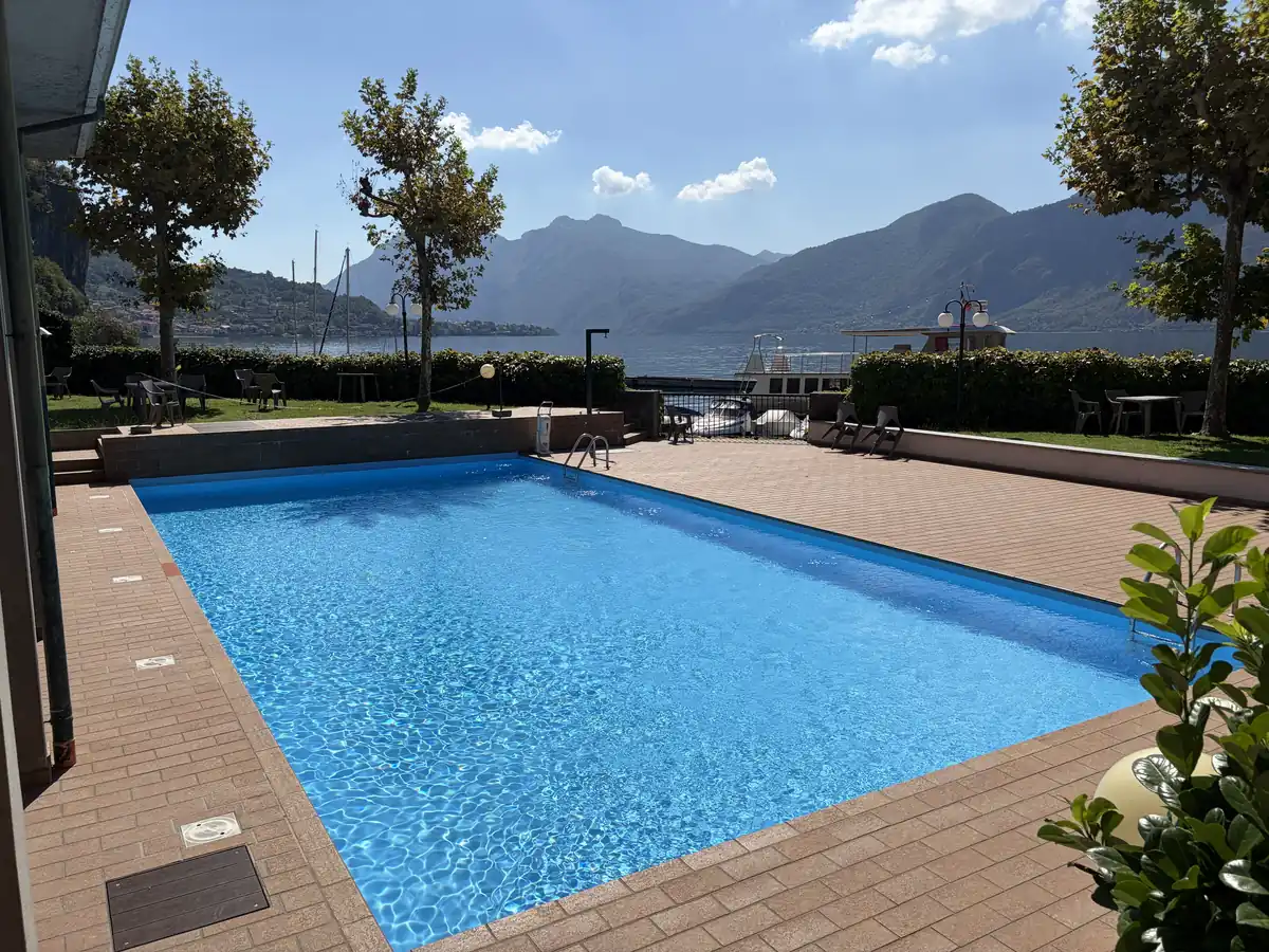 La piscina della residenza, con il lago e le montagne dietro