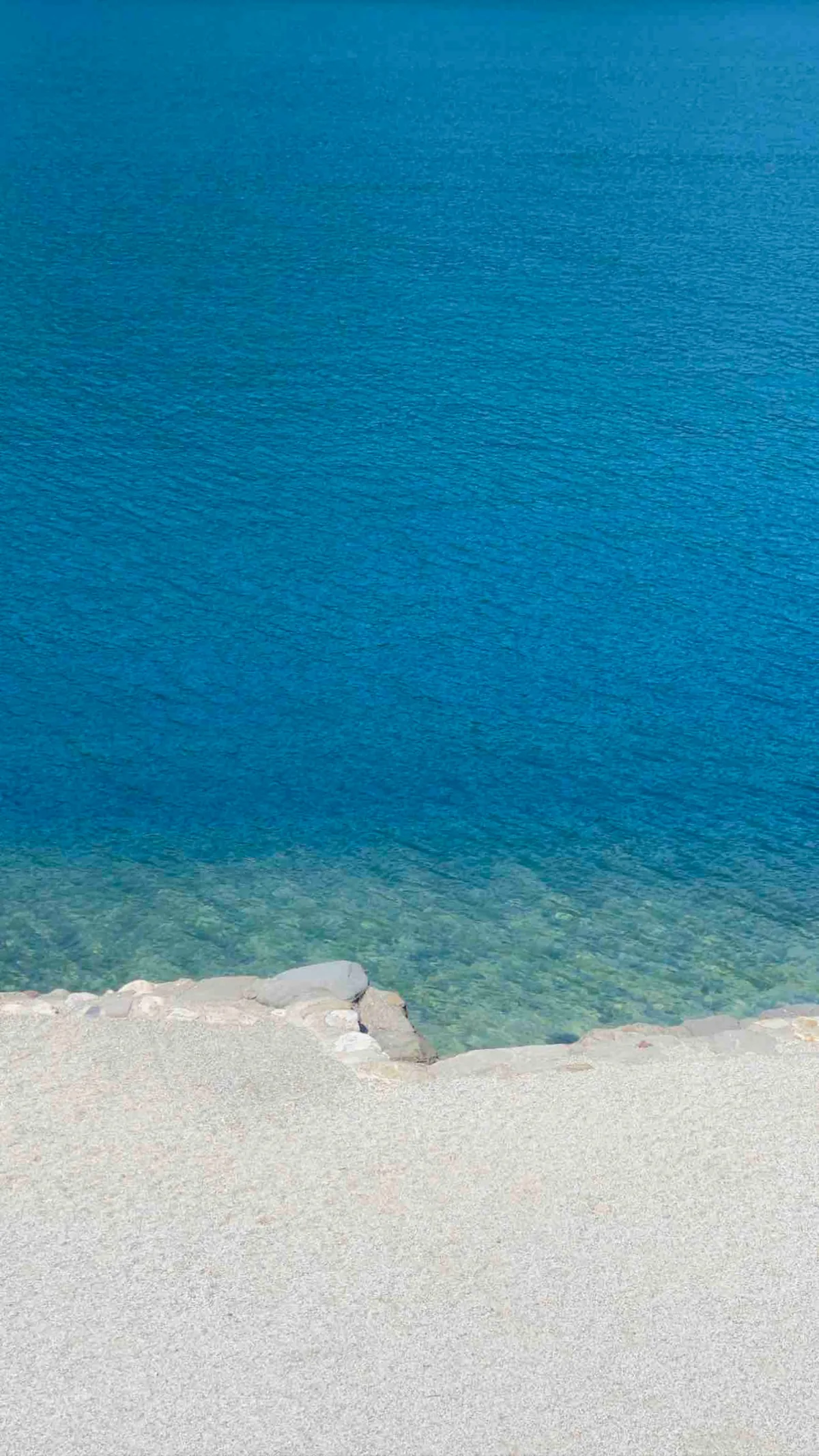 L'acqua trasparente e i ciottoli bianchi della spiaggia